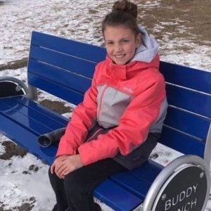 Girl sitting on Buddy Bench in School yard