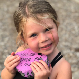 Little girl holding a painted rock